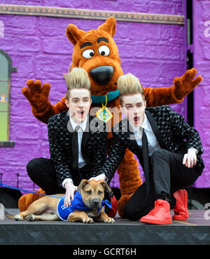 John und Edward Grimes, bekannt als Jedward, führen mit dem Scooby Doo! Charakter, um den neuen Animationsfilm "Scooby-Doo! Camp Scare' und Videospiel 'Scooby-Doo! Und das Spooky Swamp'at Battersea Dogs and Cats Home in London. Stockfoto