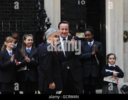 Premierminister David Cameron sagt Auf Wiedersehen zum chilenischen Präsidenten Sebastian Pinera, nachdem sie sich heute in der Downing Street 10 trafen, wo die örtlichen Schulkinder ihm Kunstwerke zeigten, die sie von den chilenischen Bergarbeitern gezeichnet hatten, als sie freigelassen wurden. Stockfoto