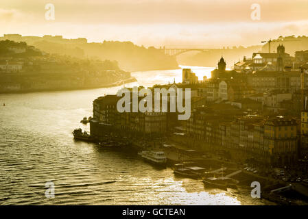 Douro-Fluss in der Stadt Porto bei Sonnenuntergang mit Ponte da Arrabida Brücke im Hintergrund. Portugal. Stockfoto