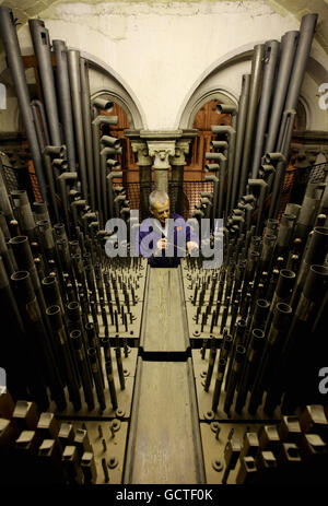 Orgel Tuner David Wintle bei der Arbeit im Orgelloft der Canterbury Cathedral in Canterbury, Kent, während er eine von über 3000 Pfeifen im Loft spielt, aus denen die Orgel besteht, von der einige Teile über 300 Jahre alt sind. Stockfoto