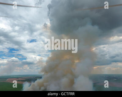 Quadrocopter Propeller auf dem Hintergrund des Rauches. Brennendes Stroh im Feld. Stockfoto