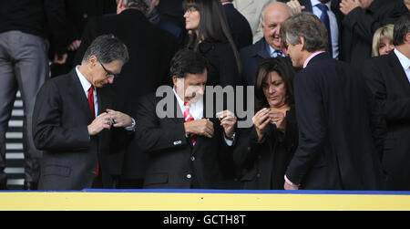 Die neuen Eigentümer John W Henry (L) und Thomas Werner (C) aus Liverpool haben ihre „One Game, One Community“-Abzeichen mit dem Vereinsvorsitzenden Martin Broughton (R) Stockfoto