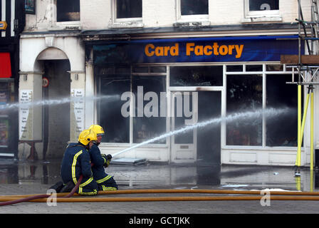 Feuerwehrleute arbeiten daran, einen Brand im Card Factory Shop zu löschen, der auch die Geschäfte River Island und Phone 4U in High Town, Hereford, betroffen hat. Stockfoto