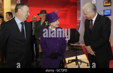 Die britische Königin Elizabeth II trifft den Group CEO von UTV Media plc John McCann (links) und den Sender Paul Clarke während eines Besuchs in den Ulster Television Studios in Belfast, wo sie den Sender HD Service angeschaltet hat. Stockfoto