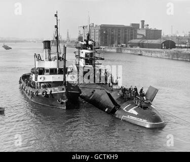 Großbritanniens erstes atomares U-Boot HMS Dreadnought sieht aus wie ein riesiger Wal, als sie sich langsam durch das Devonshire Dock, Barrow-in-Furness, begleitet vom Schlepper ST Roa, bewegt. Sie wird auf ihre Seeversuche vorbereitet. Stockfoto