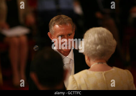 Königin Elizabeth II. Überreicht Mr. Shane Sutton aus Cardiff während einer Investitur im Buckingham Palace eine Offiziersmedaille des British Empire (OBE). Stockfoto