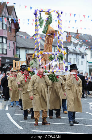 Flitch Träger tragen die Flitch während der Dunmow Flitch Versuche in Great Dunmow, Essex, eine Tradition, die bis ins frühe 12. Jahrhundert zurückreicht, wo erfolgreiche Paare einen Eid ablegen und sind mit einem Flitch Speck präsentiert. Stockfoto