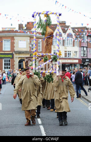 Flitch Träger tragen Flitch Speck während der Dunmow Flitch Versuche in Great Dunmow, Essex, eine Tradition, die bis ins frühe 12. Jahrhundert zurückreicht, wo erfolgreiche Paare einen Eid ablegen und sind mit einem Flitch Speck präsentiert. Stockfoto