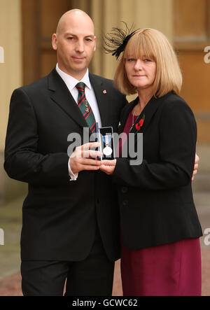 Steve und Angela Robinson, die Eltern von Rifleman Ross Robinson, mit seiner Queen's Gallantry Medal, die von Queen Elizabeth II. Posthum im Buckingham Palace in London verliehen wurde. Stockfoto