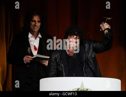 Neil schon von Journey (rechts), der den Event of the Year Award im Namen der Gruppen einsammelte, mit der Moderatorin Alice Cooper auf der Bühne, beim Marshall Classic Rock Roll of Honor, im Roundhouse im Norden Londons. Stockfoto