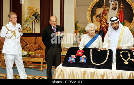 Königin Elizabeth II. Tauscht Geschenke mit Scheich Khalifa bin Zayed al Nahyan, dem Präsidenten der Vereinigten Arabischen Emirate (rechts), aus, während der Herzog von Edinburgh (Mitte links) und der Herzog von York (ganz links) heute Nachmittag im Mushrif Palace in Abu Dhabi zusehen. Stockfoto