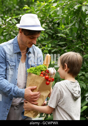 junger Mann und sein Sohn mit einem Papier Tasche shopping natürliche Bio-Produkte Stockfoto