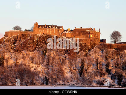 Ein schneebedecktes Stirling Castle leuchtet bei Sonnenuntergang rot, während der Kälteeinbruch Großbritannien weiterhin trifft. Stockfoto