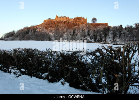 Ein schneebedecktes Stirling Castle leuchtet bei Sonnenuntergang rot, während der Kälteeinbruch Großbritannien weiterhin trifft. Stockfoto