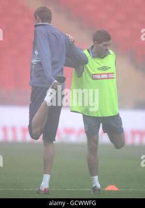 Fußball - Internationale Freundschaften - England gegen Frankreich - England Trainings- und Pressekonferenz - Wembley Stadium. Englands Peter Crouch (links) und Steven Gerrard (rechts) strecken sich während des Trainings Stockfoto