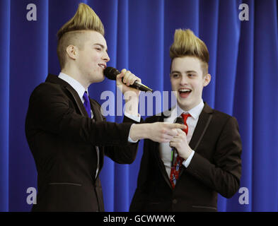 John (blaue Krawatte) und Edward Grimes aka Jedward sprechen mit Schülern von Craigdhu Primary, während sie vor ihrem Konzert in Glasgow eine Recycling-Kampagne zugunsten von Childline in Milngavie auf ihrer Schulversammlung fördern. Stockfoto