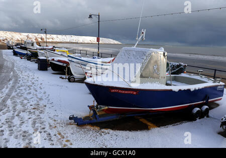 Fischerboote sitzen in Filey, North Yorkshire, mit Schnee bedeckt, da an der Ostküste Großbritanniens mehr Schneefälle vorhergesagt werden. Stockfoto