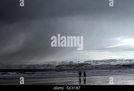 Die Menschen laufen am Strand in Filey, North Yorkshire, da an der Ostküste Großbritanniens mehr Schneefälle vorhergesagt werden. Stockfoto