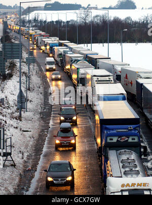 Der Verkehr steht Schlange, um in den Eurotunnel-Standort in Folkestone, Kent, einzudringen, da schlechtes Wetter weiterhin für Reisende Probleme bereitet. Stockfoto