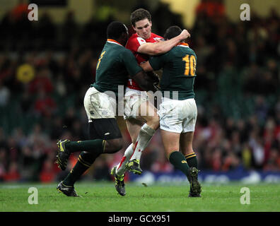 Wales George North wird von den Südafrikanern Tendai Mtawarira und Morne Steyn während des Spiels der Investec Perpetual Series im Millennium Stadium in Cardiff angegangen. Stockfoto