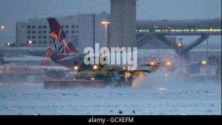 Ein Schneepflug versucht, die Start- und Landebahn am Flughafen Gatwick zu räumen, nachdem Schnee und Frost den Flughafen geschlossen haben. Stockfoto