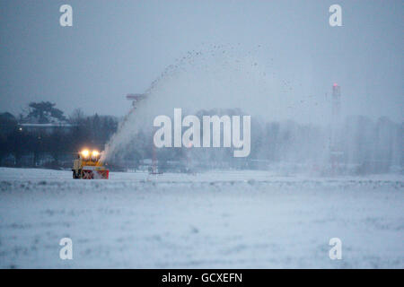 Ein Schneepflug versucht, die Start- und Landebahn am Flughafen Gatwick zu räumen, nachdem Schnee und Frost den Flughafen geschlossen haben. Stockfoto