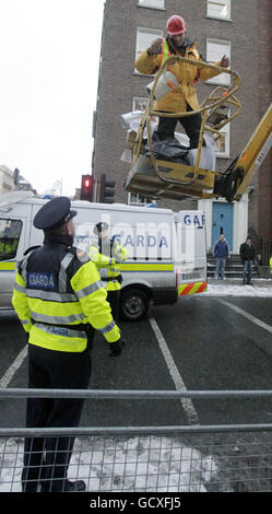 Ein Mann in einem Kirschbaum, der mit einer Reihe von Slogans bedeckt ist, die Politiker und den Bankensektor angreifen, um vor den Toren des Leinster House, Dublin, zu protestieren, unterhält sich am Budgettag mit gardai. DRÜCKEN SIE VERBANDSFOTO. Bilddatum: Dienstag, 7. Dezember 2010. Der Demonstrator parkte den Kran in der Nähe des Dails. Das Kontrollfeld wurde abgedichtet, wodurch gardai daran gehindert wurde, den Protestierenden wieder zu Boden zu bringen. Siehe Geschichte der PA IRISCHE Budgetproteste. Bildnachweis sollte lauten: Niall Carson/PA Wire Stockfoto
