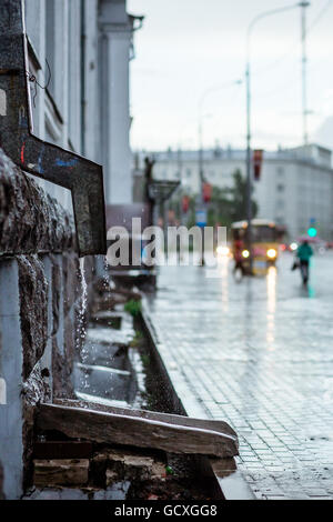 Regen Sie, Wasser fließt aus Metall Fallrohr während einer Überschwemmung. Konzept des Schutzes gegen die heftigen Regenfälle Stockfoto