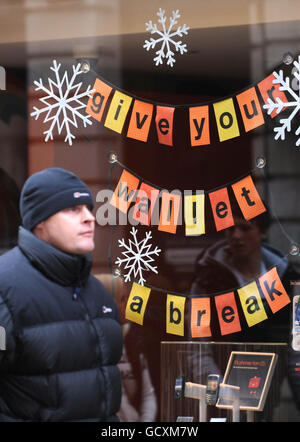 Verkäufe am zweiten Weihnachtsfeiertag. Ein Mann kommt an einem Schild vorbei, das in einem Schaufenster während des Weihnachtsverkaufs im Stadtzentrum von York ausgestellt ist. Stockfoto