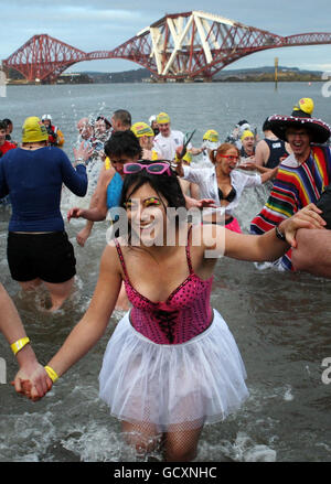 Schwimmer trotzen der Kälte im River Forth in der Nähe von Edinburgh, während der Loony Dook, einer der jährlichen Neujahrsschwimmer, die in ganz Großbritannien stattfinden. Stockfoto