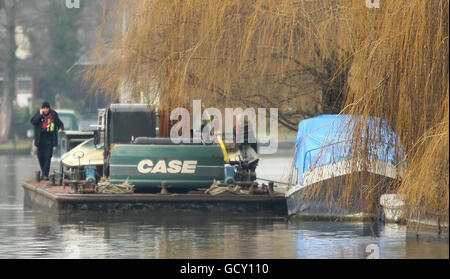 Die Polizei entfernt ein kleines Boot von einem Abschnitt der Themse in der Nähe von Pharoah's Island, in Shepperton, Surrey, als sie nach zwei vermissten Männern suchen, nachdem ein Boot mit sechs Passagieren gestern Abend gekentert war. Stockfoto