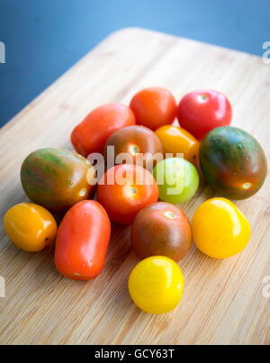 Eine schöne, bunte Palette von Sommer Tomatensorten auf einem Bambus-Oberfläche. Stockfoto