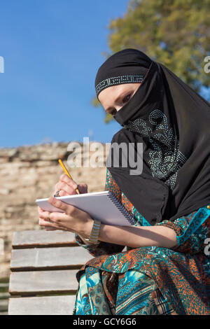 Arabische Frau Skizze in Papier Notizblock mit Bleistift Stockfoto