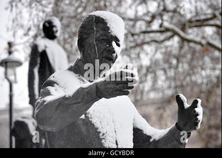 Eine Statue von Nelson Mandela auf dem Parliament Square ist mit Schnee bedeckt, wenn das Winterwetter in die Hauptstadt zurückkehrt. Stockfoto