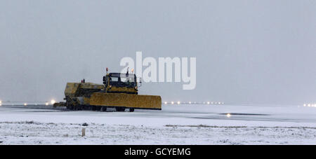 Ein Schneepflug versucht, die Start- und Landebahn am Liverpool John Lennon Airport zu räumen, nachdem schlechtes Wetter sie gezwungen hatte, sich zu schließen und Flüge umgeleitet wurden. Stockfoto