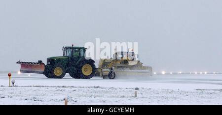 Ein Schneepflug versucht, die Start- und Landebahn am Liverpool John Lennon Airport zu räumen, nachdem schlechtes Wetter sie gezwungen hatte, sich zu schließen und Flüge umgeleitet wurden. Stockfoto