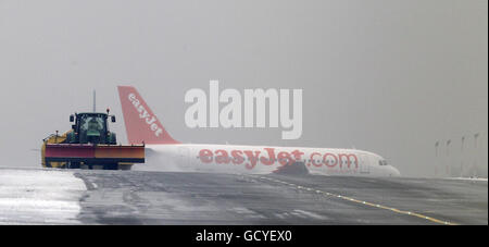 Ein Schneepflug versucht, die Startbahn am Liverpool John Lennon Airport zu räumen, nachdem das schlechte Wetter zuvor die Startbahn gezwungen hatte, zu schließen und Flüge umzuleiten. Stockfoto