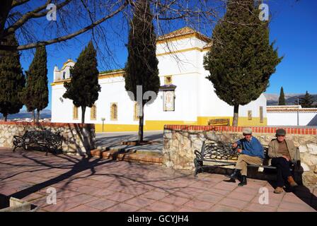 Zwei ältere spanische Männer sitzen auf der Bank vor der Maria Santísima De La Candelaria Kirche, Colmenar, Andalusien, Spanien. Stockfoto