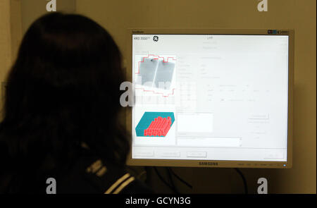 UK Border Agency Drug Detection. Ein Offizier der britischen Grenzbehörde nutzt eine Xylon-Maschine, um Drogen zu erkennen, die durch den Flughafen Heathrow geschmuggelt wurden. Stockfoto