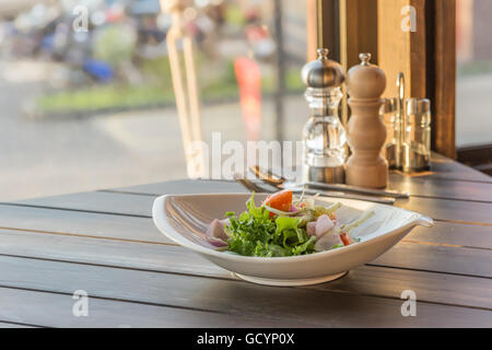 Olivenöl in Schüssel Salat gießen Stockfoto