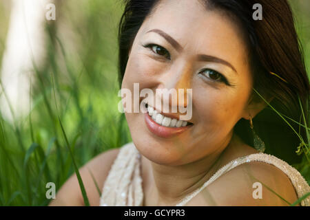 Asiatische Frau sitzen auf der Wiese Stockfoto