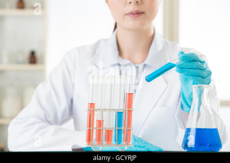 Junge asiatische Wissenschaftler im Bereich Life Science im Labor mit Handschuhen pipettieren Stockfoto