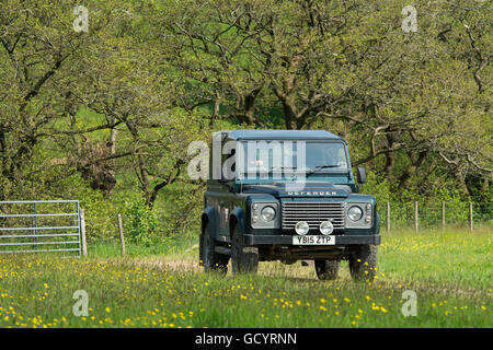 Bauern fahren einen Land Rover Defender über ein Feld, Lancashire, UK. Stockfoto