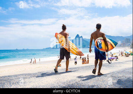RIO DE JANEIRO - 3. April 2016: Junge Carioca Fuß Brasilianer mit Surfbrettern Arpoador, der beliebte Surf-Punkt. Stockfoto