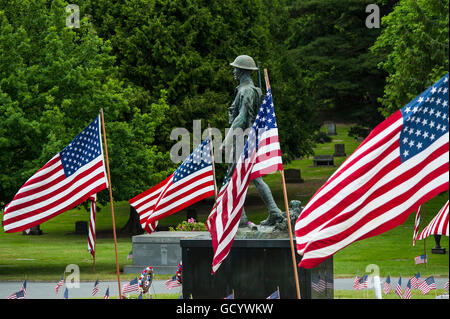 Memorial Day Zeremonie am Friedhof mit amerikanischen Flaggen, militärische Skulptur und Fahnen auf Grabstätten Stockfoto