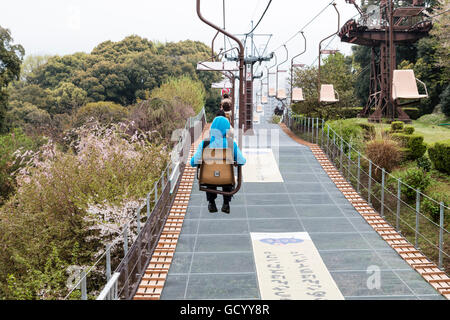 Japan, Iyo Matsuyama Schloss. Seilbahn, Sessellift, auf und zusammen mit der Stadt Hintergrund mit kleinen Jungen vorne in blau Hoodie Top. Stockfoto