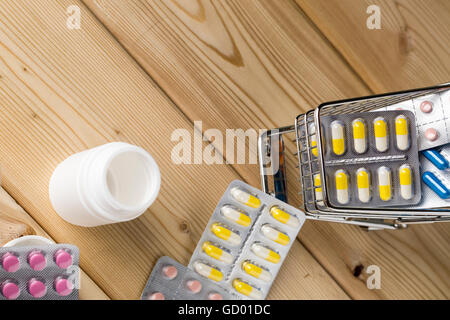 Haufen Medizin bunte Pillen Blister Pack und Wasserglas Stockfoto
