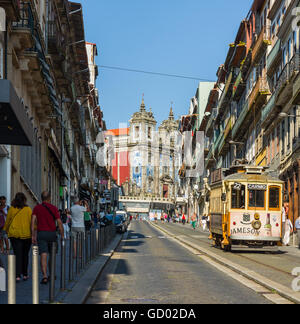 Straßenbahn über Rua 31 de Janeiro Straße mit Kirche Igreja de Santo Ildefonso im Hintergrund. Porto. Portugal. Stockfoto