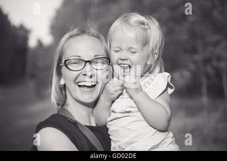 Glückliche Familie. Junge glückliche schöne Mutter und ihre Tochter Spaß im Freien. Positive Emotionen, Gefühle. Stockfoto