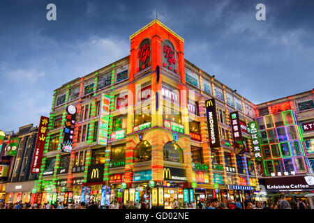 Fußgänger passieren Shangxiajiu Fußgängerzone in Guangzhou, China. Stockfoto